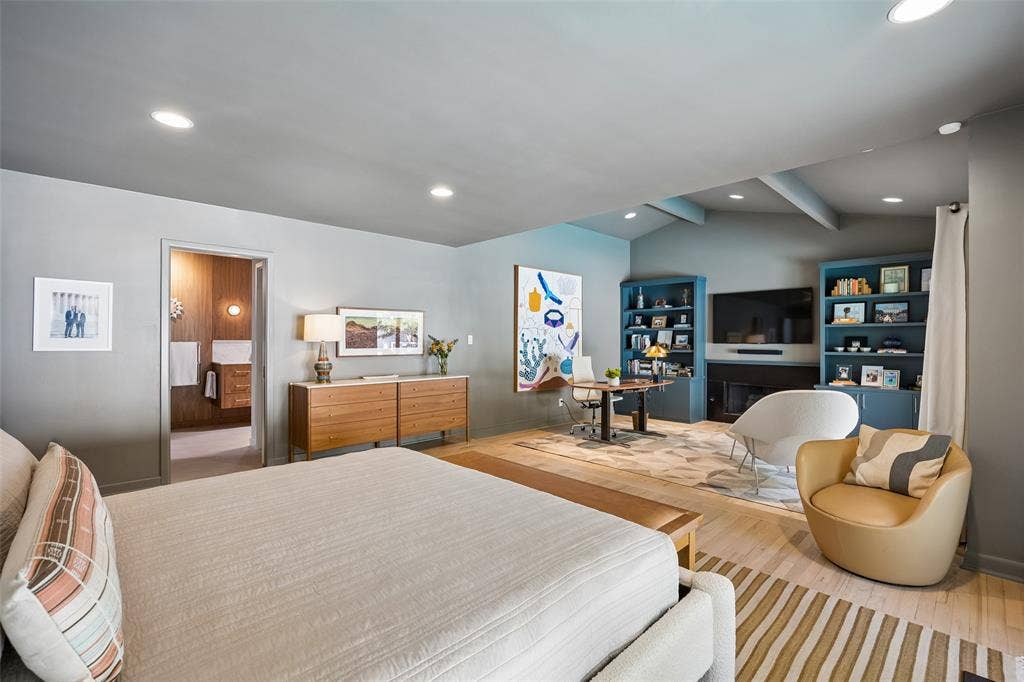 The oversized primary suite is truly exceptional, featuring a separate sitting room with fireplace and built-ins overlooking the backyard and pool.