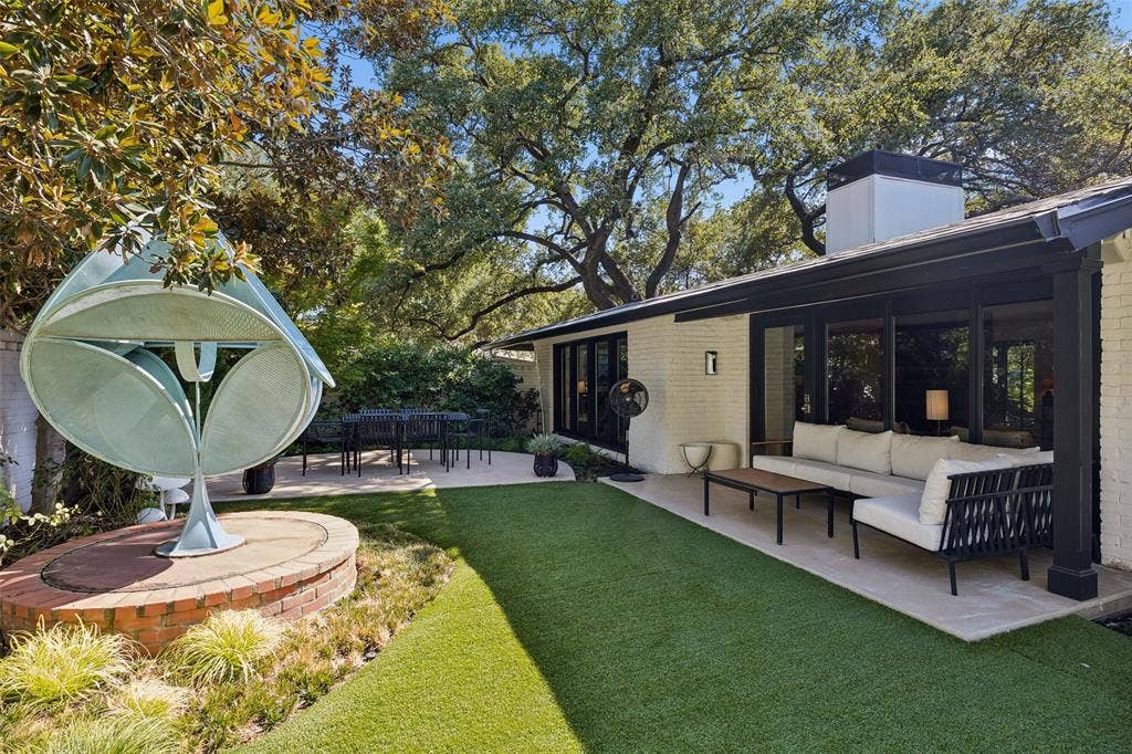 Beautiful back yard with turf, covered patio and outdoor dining area.