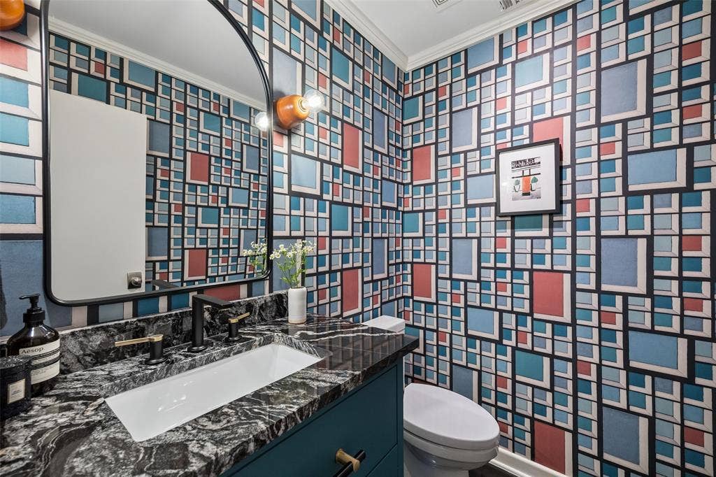 Charming powder bathroom with Kelly Wearstler wall covering.