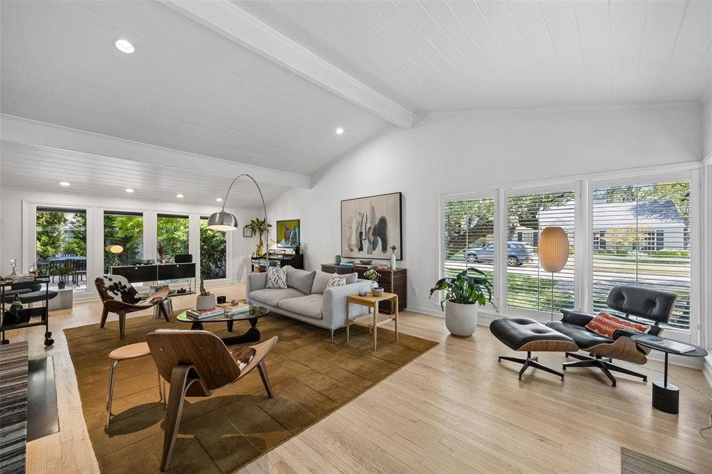 Inside, a generous living room features a double-sided wood-burning fireplace, vaulted ceilings and expansive views of the backyard.