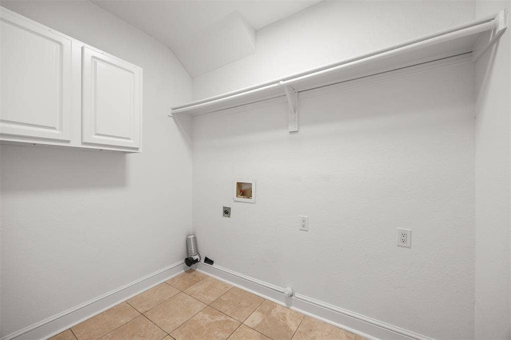 4203 N Capistrano Drive, Dallas, TX 75287 Laundry room has hookups for electric washer and dryer, shelving, cabinet, custom baseboard, and Travertine flooring.