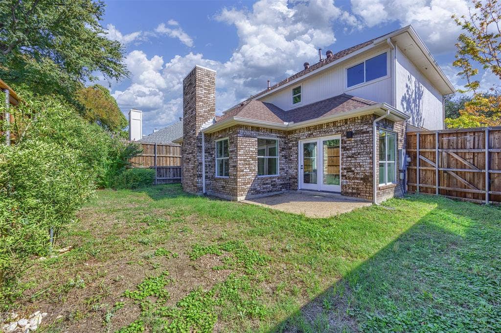 4203 N Capistrano Drive, Dallas, TX 75287 Rear photograph of home showing the patio door, patio and yard. There is a natural gas line hookup on the patio for a gas grill.