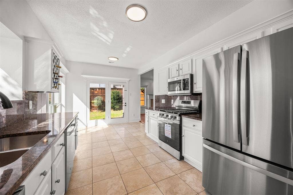 4203 N Capistrano Drive, Dallas, TX 75287 Beautiful granite countertops and backsplash installed with under and over cabinet lighting, wine storage cabinet, soft close hinges on all doors and LED lighting. Travertine flooring tile is installed throughout the kitchen and breakfast area