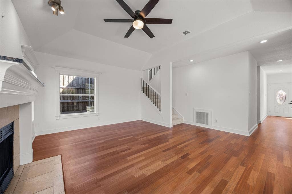 4203 N Capistrano Drive, Dallas, TX 75287 Photograph showing the front door, hallway, living room and stairs to the second floor. All flooring in these areas are Brazilian Cherry hardwood. The floors are not engineered, plywood strand oriented board (OSB) or Medium Density Fiberboard (MDF)
