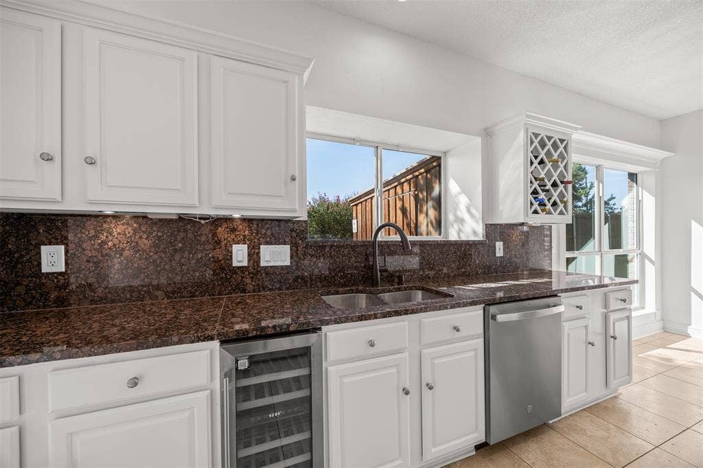 4203 N Capistrano Drive, Dallas, TX 75287 Photograph showing, granite counter top, upper and lower cabinets, new GE dishwasher and under counter beverage refrigerator.