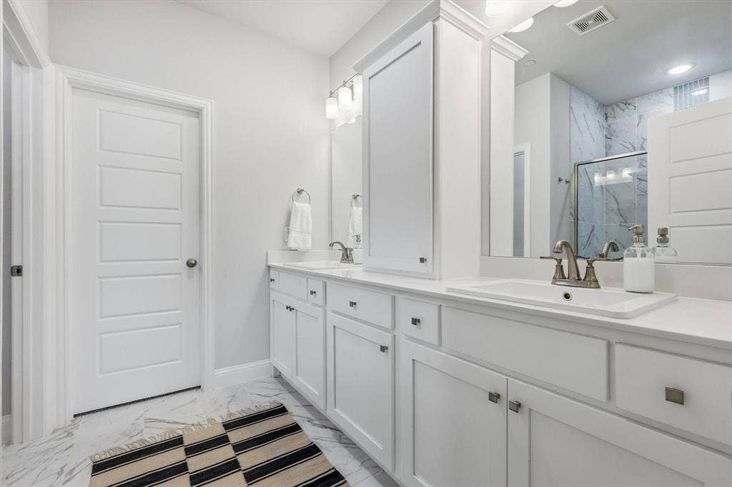 12952 Wymeth Drive, Farmers Branch, TX 75234 Primary bathroom featuring walk-in closet, water closet and two vanities