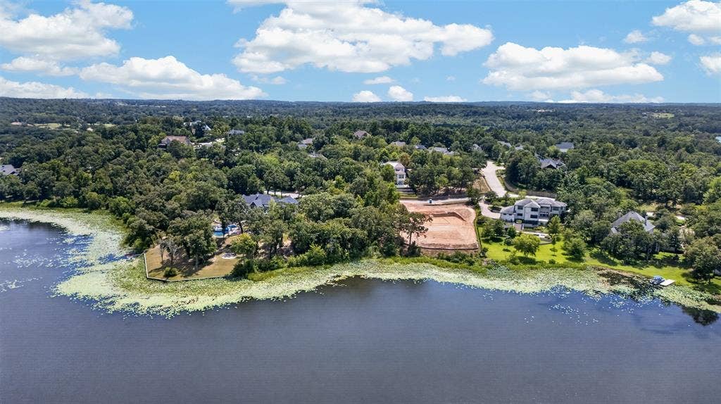 4513 Cascades Shoreline Drive, Tyler, TX 75709 Waterfront property featuring mature trees, and a developed surrounding area