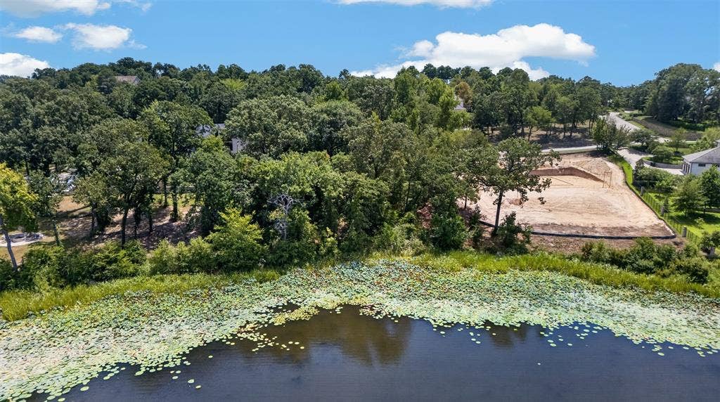 4513 Cascades Shoreline Drive, Tyler, TX 75709 Lakefront property, mature trees, and surrounding natural foliage