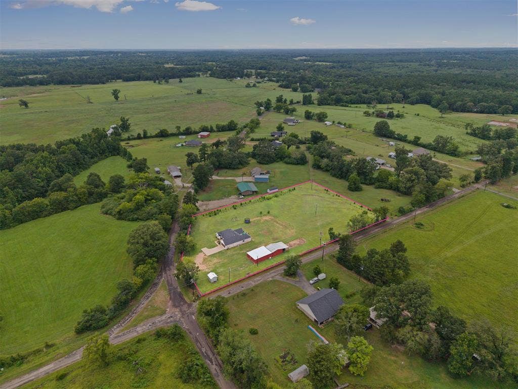 22477 County Road 2166, Troup, TX 75789 Expansive property featuring a residence, detached garage, and barn, surrounded by lush green fields