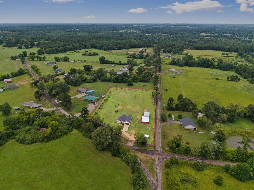 22477 County Road 2166, Troup, TX 75789 Expansive green landscape with scattered residential properties, mature trees, and a visible pond