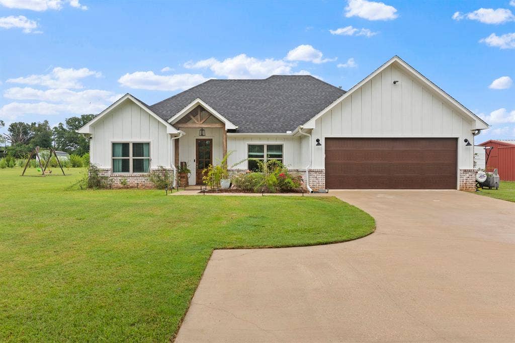 22477 County Road 2166, Troup, TX 75789 White board-and-batten siding with a dark asphalt shingle roof