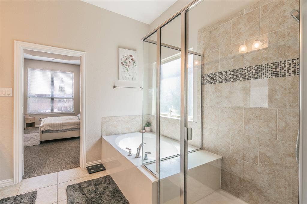 3020 Bella Lago Drive, Fort Worth, TX 76177 Glass-enclosed shower with tiled walls and decorative mosaic accent