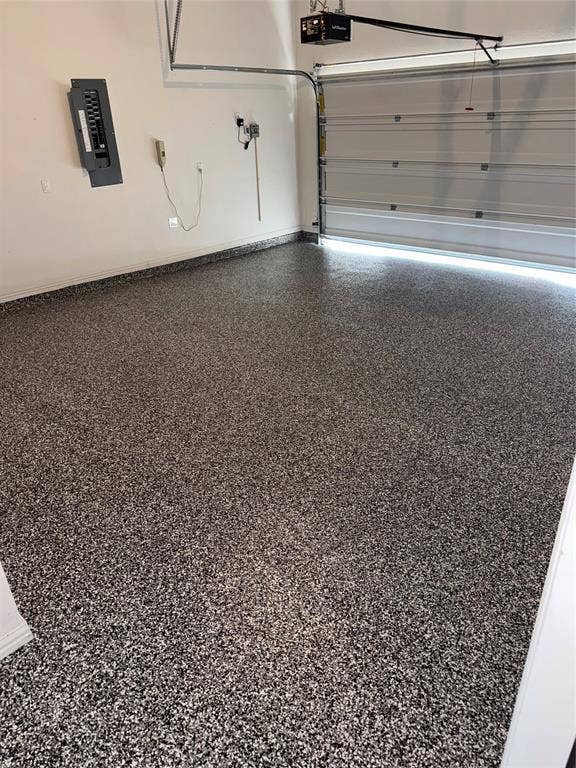 3020 Bella Lago Drive, Fort Worth, TX 76177 Garage featuring a speckled epoxy floor, white walls, and an automatic overhead door