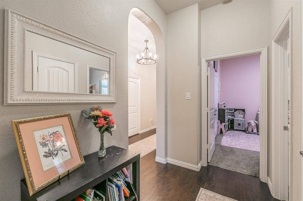3020 Bella Lago Drive, Fort Worth, TX 76177 Arched hallway entrance with dark wood-finish flooring in between the 2 bedrooms