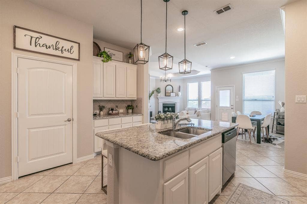 3020 Bella Lago Drive, Fort Worth, TX 76177 Kitchen island with an undermount double-basin sink and granite countertop