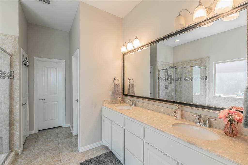 3020 Bella Lago Drive, Fort Worth, TX 76177 Dual vanity with undermount sinks, an expansive framed mirror, and a multi-light fixture