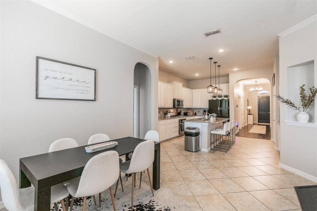 3020 Bella Lago Drive, Fort Worth, TX 76177 Kitchen with white cabinetry, stainless steel appliances, and a central island with bar seating