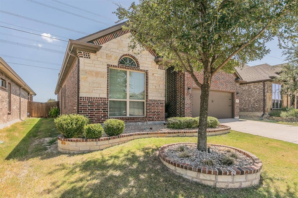 3020 Bella Lago Drive, Fort Worth, TX 76177 Brick and stone exterior with an arched window, attached garage, and mature landscaping
