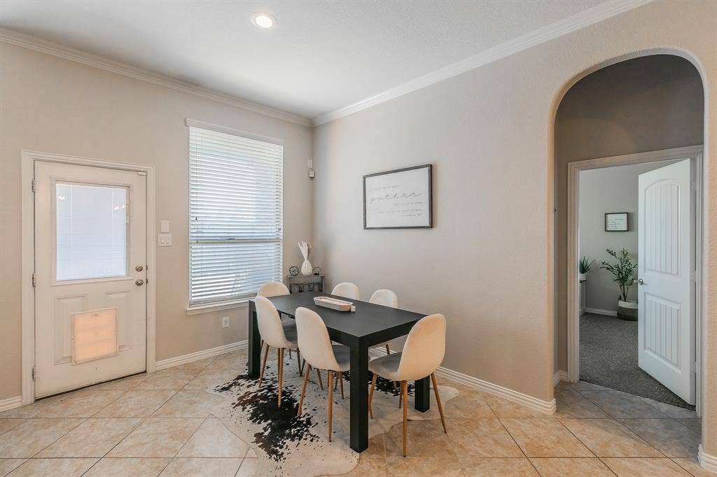 3020 Bella Lago Drive, Fort Worth, TX 76177 Recessed lighting, crown molding, arched doorway, tiled flooring, and a paneled door with dog entry.