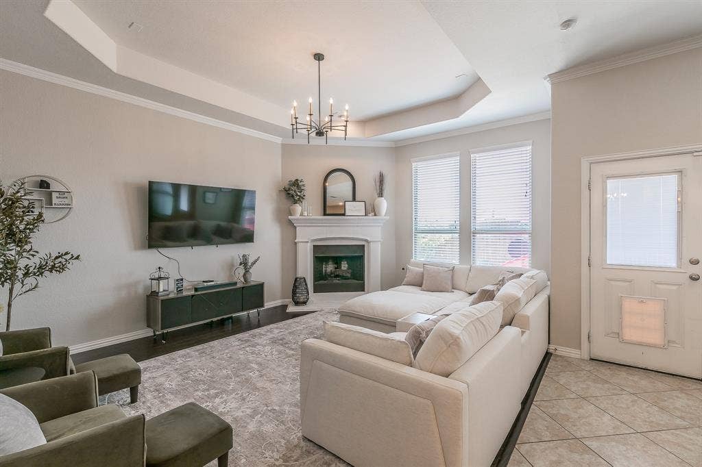 3020 Bella Lago Drive, Fort Worth, TX 76177 Tray ceiling, dark wood-finish flooring, white fireplace, multiple windows with blinds, and a white paneled door