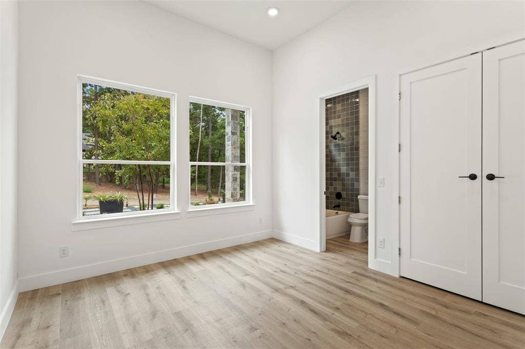 High ceilings, wood-finish flooring, dual windows, modern interior doors, and a bathroom featuring a tiled shower