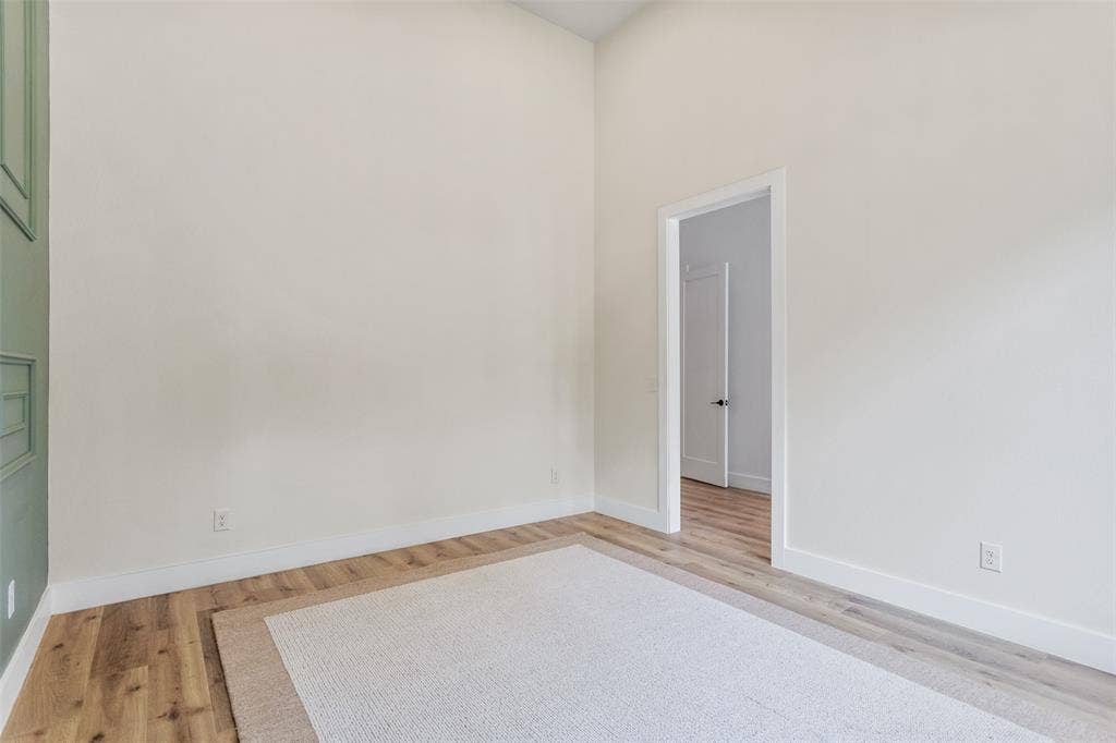 Vaulted ceiling, wood-finish flooring, and a paneled accent wall