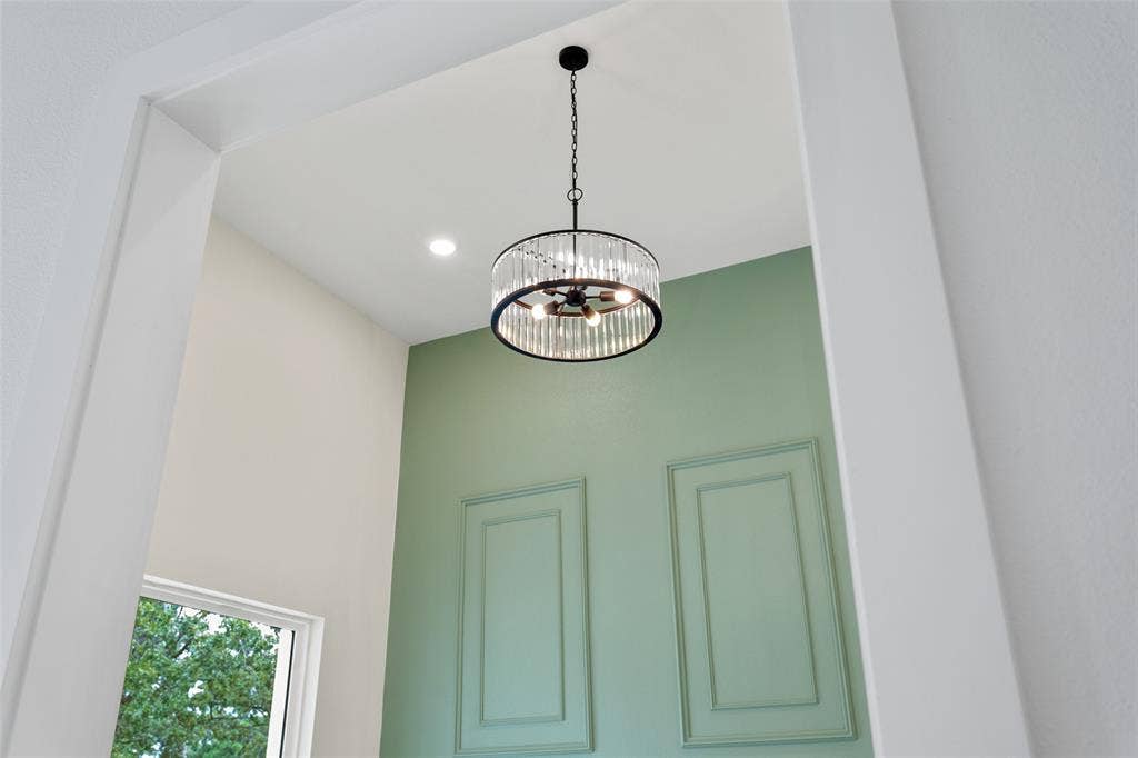 Vaulted ceiling with a contemporary chandelier and recessed lighting
