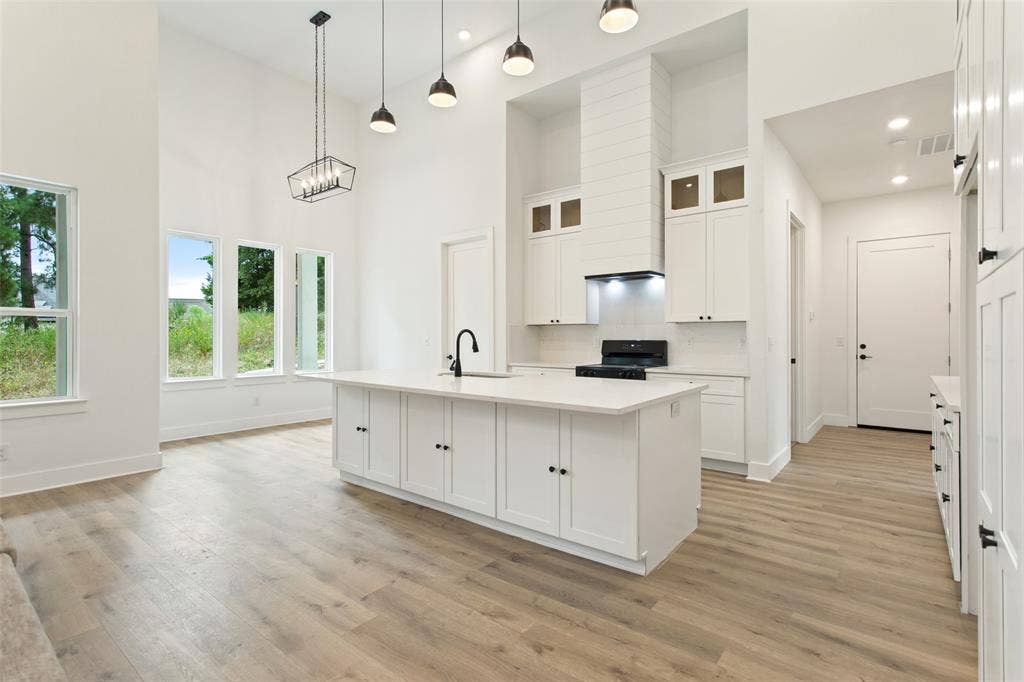 Vaulted ceilings with recessed lighting and pendant fixtures