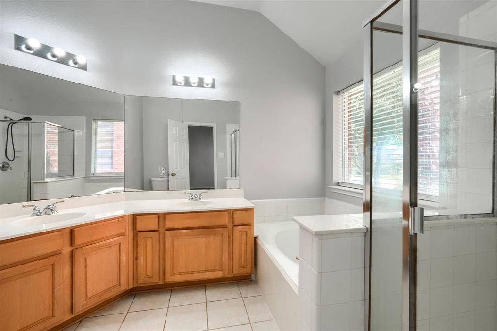 Dual vanity with light wood-finish cabinetry and white countertops