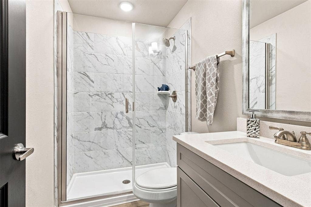 3352 Norris Street, Plano, TX 75074 Glass-enclosed shower with white tiled walls, white shower pan, and a single shower head