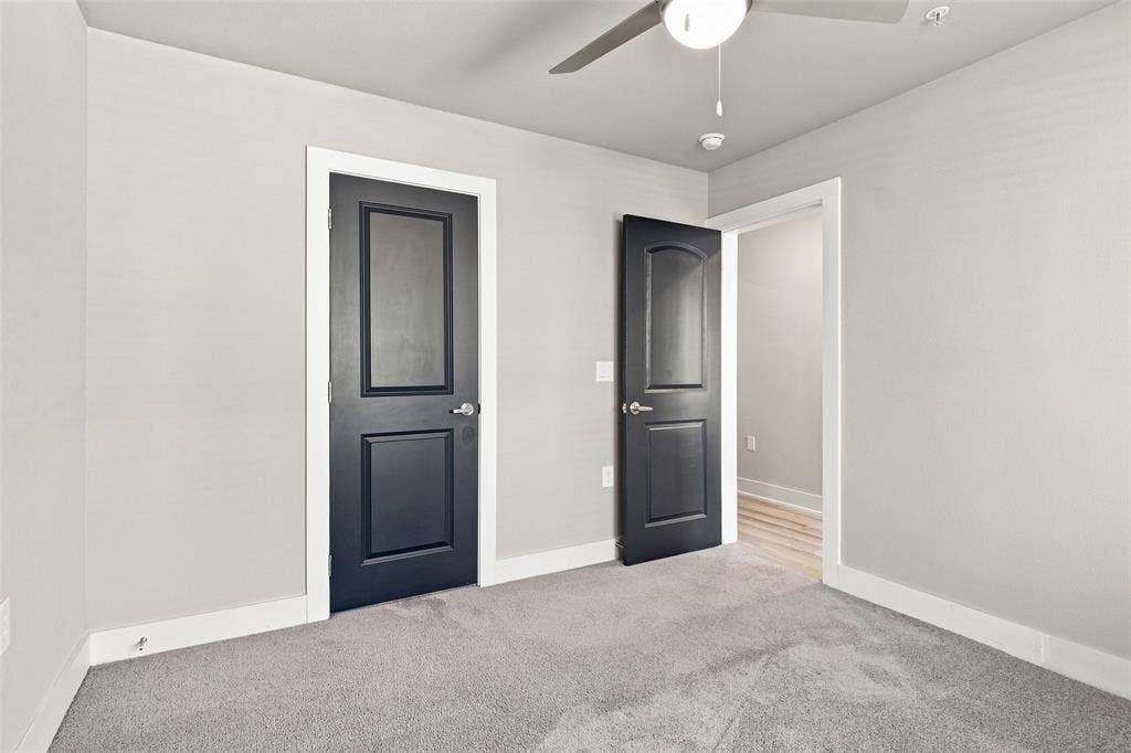 3352 Norris Street, Plano, TX 75074 Light gray walls with white trim, gray carpeting, dark paneled doors with silver-tone hardware, and an overhead ceiling fan