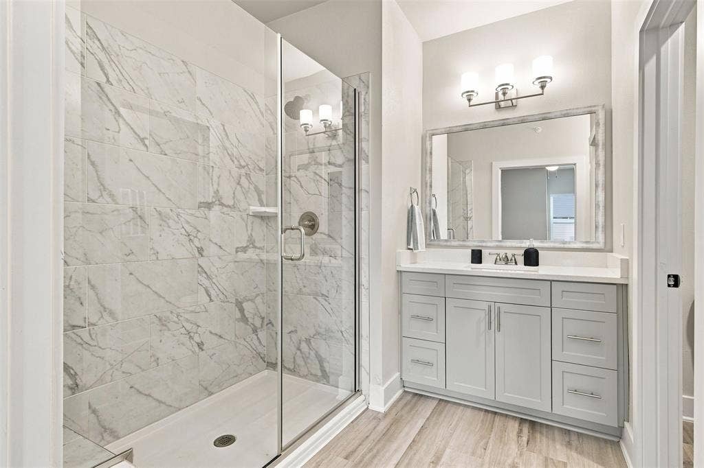 3352 Norris Street, Plano, TX 75074 Walk-in shower with full-height tile surround, clear glass enclosure, and built-in niche
