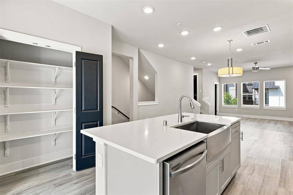 3352 Norris Street, Plano, TX 75074 Kitchen island with a farmhouse sink, stainless steel dishwasher, and a gooseneck faucet