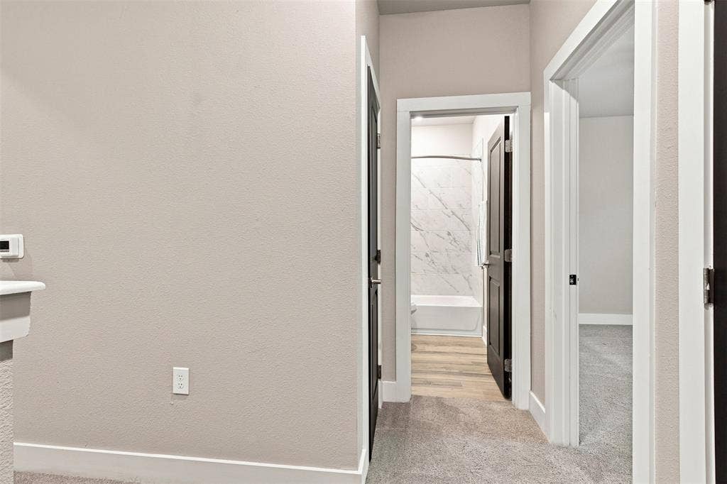 3352 Norris Street, Plano, TX 75074 Hallway with light gray wall paint, dark wood-finish interior doors, and gray carpet flooring