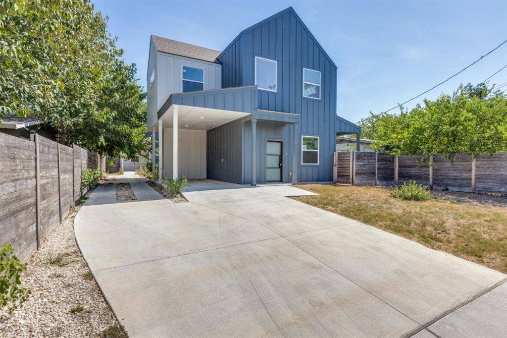 1042 Rosemont Street, #1, Austin, TX 78723 Modern architectural design featuring vertical siding, a covered entryway, and a concrete driveway