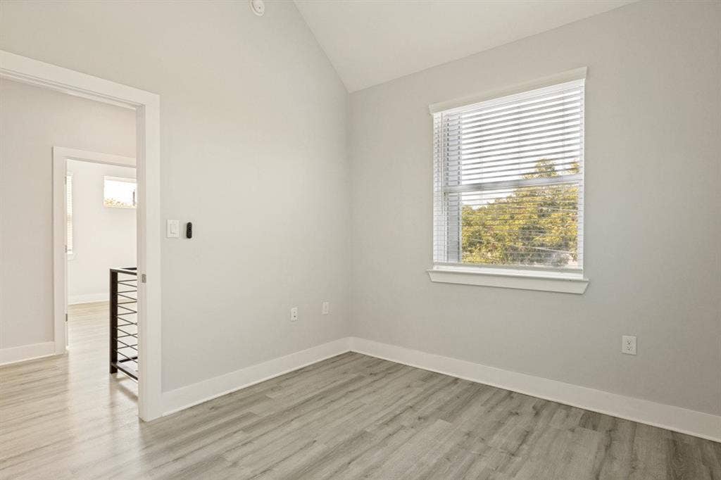 1042 Rosemont Street, #1, Austin, TX 78723 Vaulted ceiling, wood-finish flooring, white trim, and a window with blinds