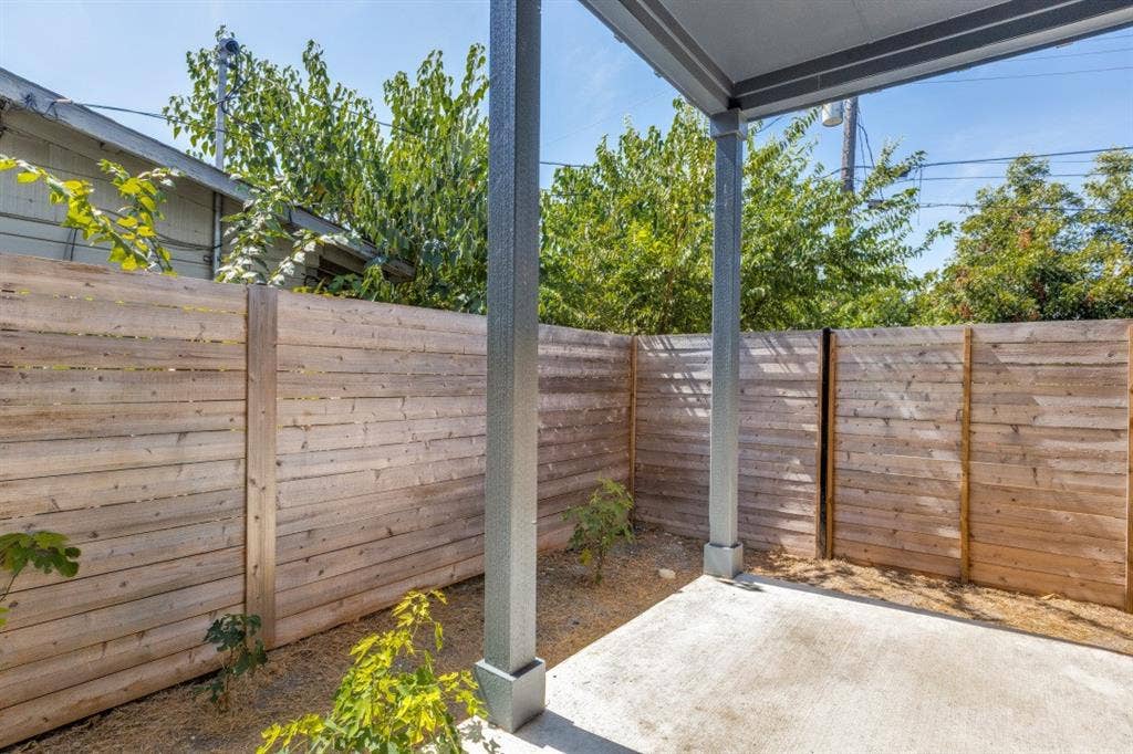 1042 Rosemont Street, #1, Austin, TX 78723 Covered concrete patio with a wood privacy fence