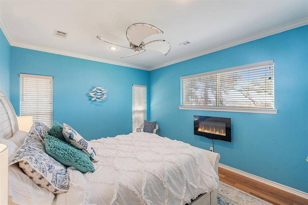 109 Briarwood Drive, Gun Barrel City, TX 75156 Room featuring a wall-mounted electric fireplace, bamboo flooring, and crown molding