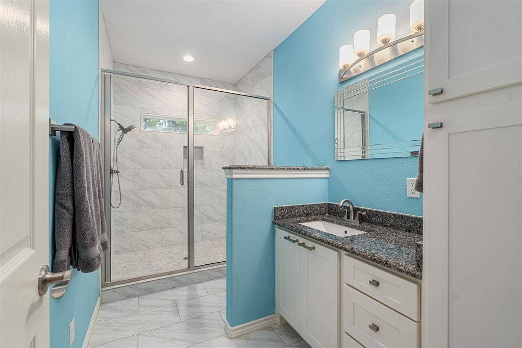 109 Briarwood Drive, Gun Barrel City, TX 75156 Glass-enclosed shower with a handheld shower fixture, white vanity with a granite-style countertop, and a built-in storage cabinet