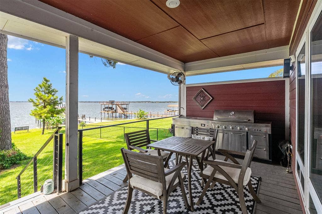 109 Briarwood Drive, Gun Barrel City, TX 75156 Covered porch with wood flooring, featuring an outdoor kitchen with a built-in grill, and a railing system