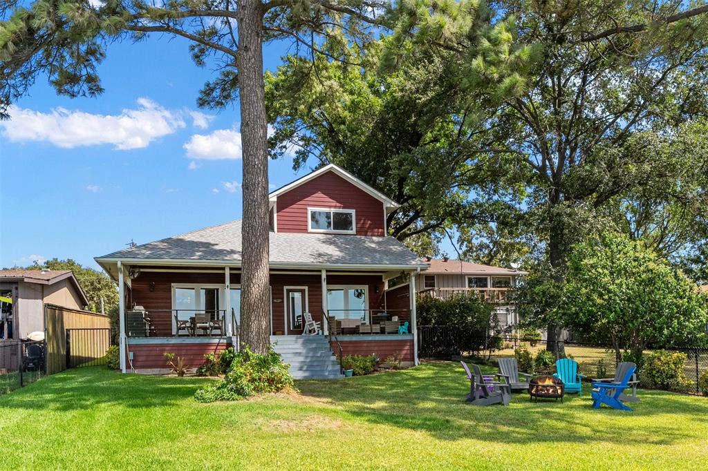 109 Briarwood Drive, Gun Barrel City, TX 75156 Red siding exterior with a partial covered porch, multiple windows, and exterior stairs