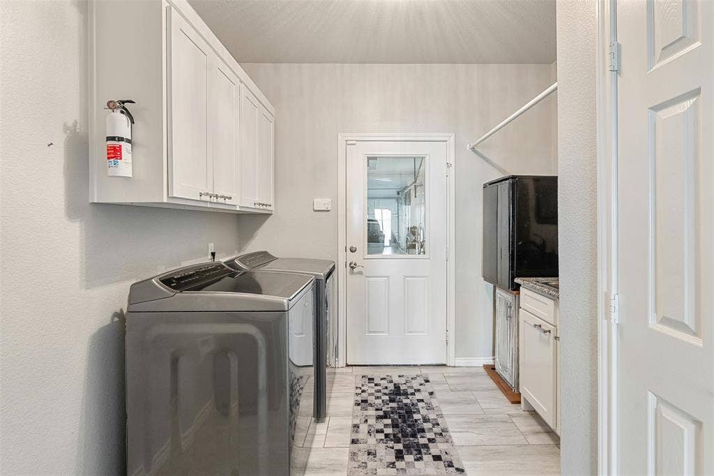 109 Briarwood Drive, Gun Barrel City, TX 75156 White wall-mounted cabinetry, a white paneled door with glass insert, light-toned tile flooring, and a built-in countertop with sink and lower cabinetry