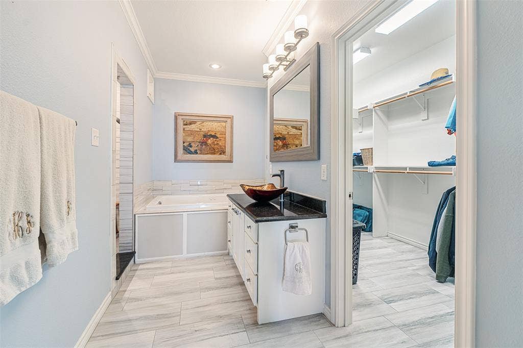 109 Briarwood Drive, Gun Barrel City, TX 75156 White cabinetry with black countertop, vessel sink, and wall-mounted mirror