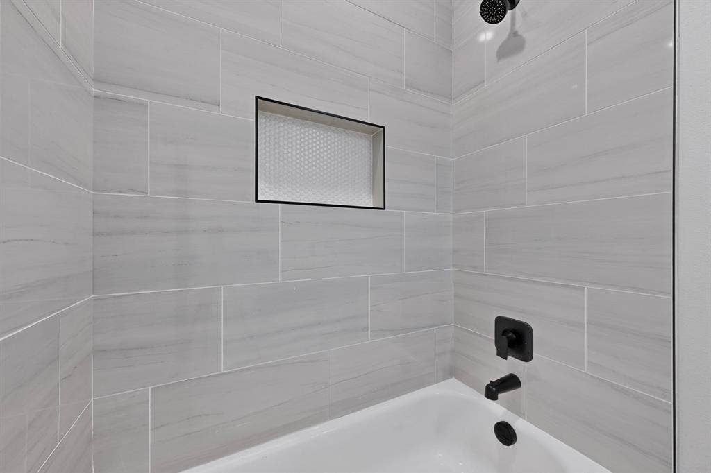 102 Redondo Drive, Gun Barrel City, TX 75156 Bathtub with matte black fixtures, an integrated shower niche with honeycomb tile, and light gray subway tile surround