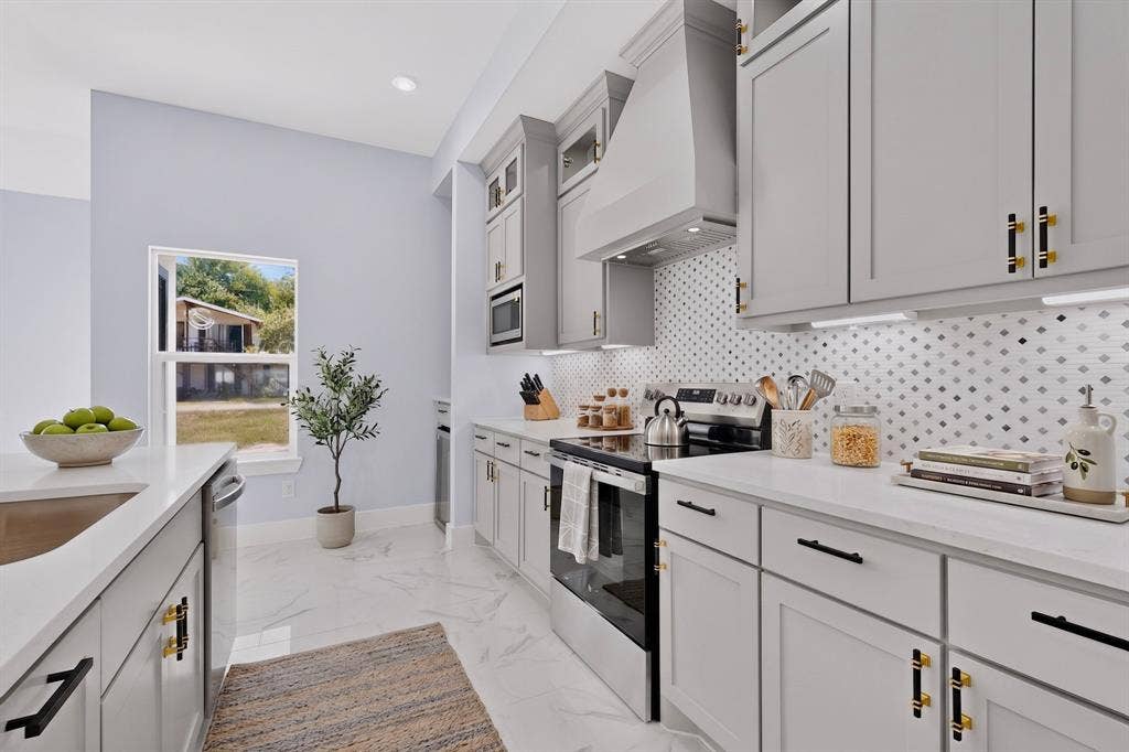 102 Redondo Drive, Gun Barrel City, TX 75156 White quartz countertops, light gray cabinetry, stainless steel appliances, patterned tile backsplash, and recessed lighting