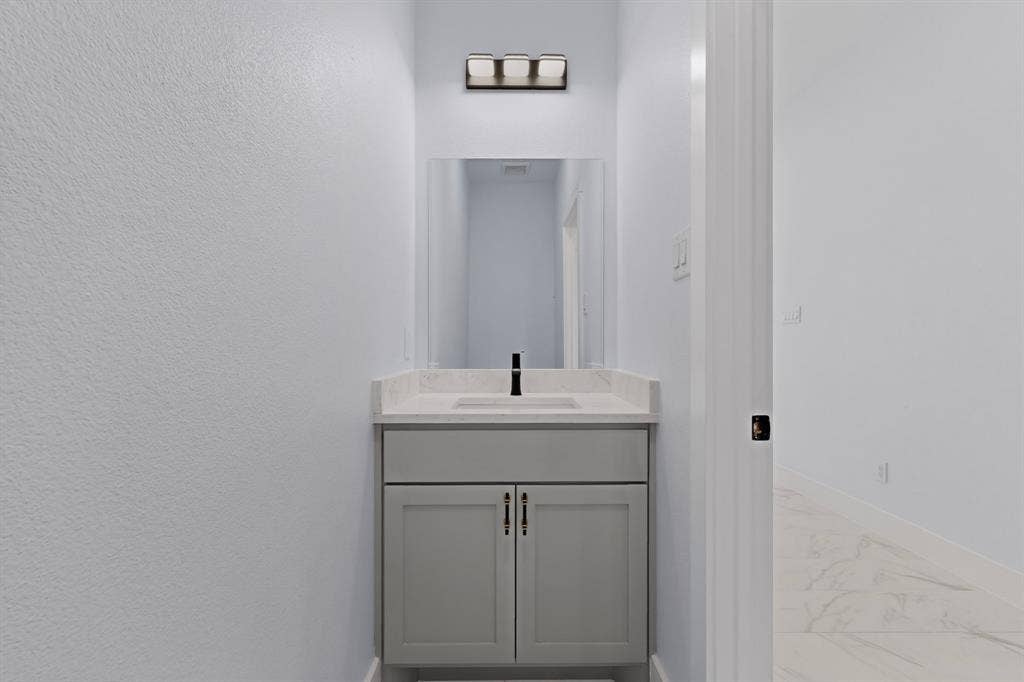102 Redondo Drive, Gun Barrel City, TX 75156 Powder room featuring a single vanity with gray cabinetry, a rectangular undermount sink, and a light-toned countertop