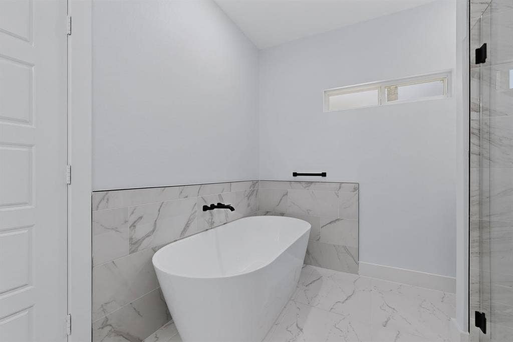 102 Redondo Drive, Gun Barrel City, TX 75156 Freestanding soaking tub with matte black fixtures, marble-look tile surround, and a clear glass shower enclosure