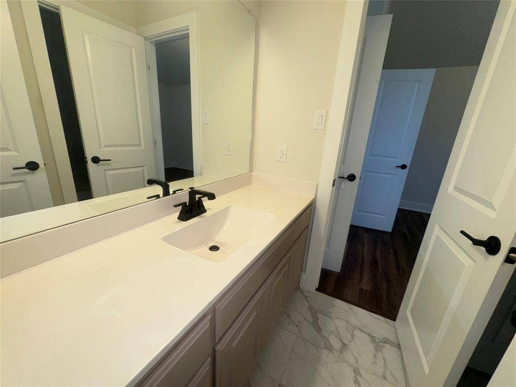1701 Shamrock Green, Mesquite, TX 75181 White vanity with a single basin, matte black faucet, and white countertop