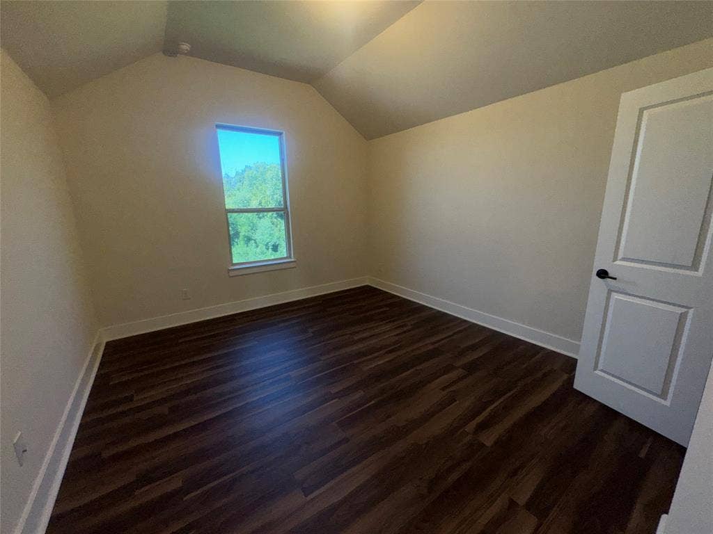 1701 Shamrock Green, Mesquite, TX 75181 Vaulted ceiling, wood-finish flooring, white trim, single window, and a paneled door with matte black hardware
