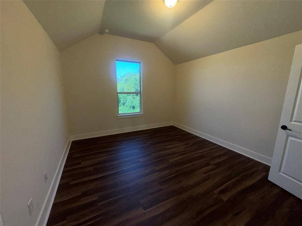 1701 Shamrock Green, Mesquite, TX 75181 Wood-finish flooring, single window, white trim, attic-style sloped ceiling, and a paneled door with dark hardware